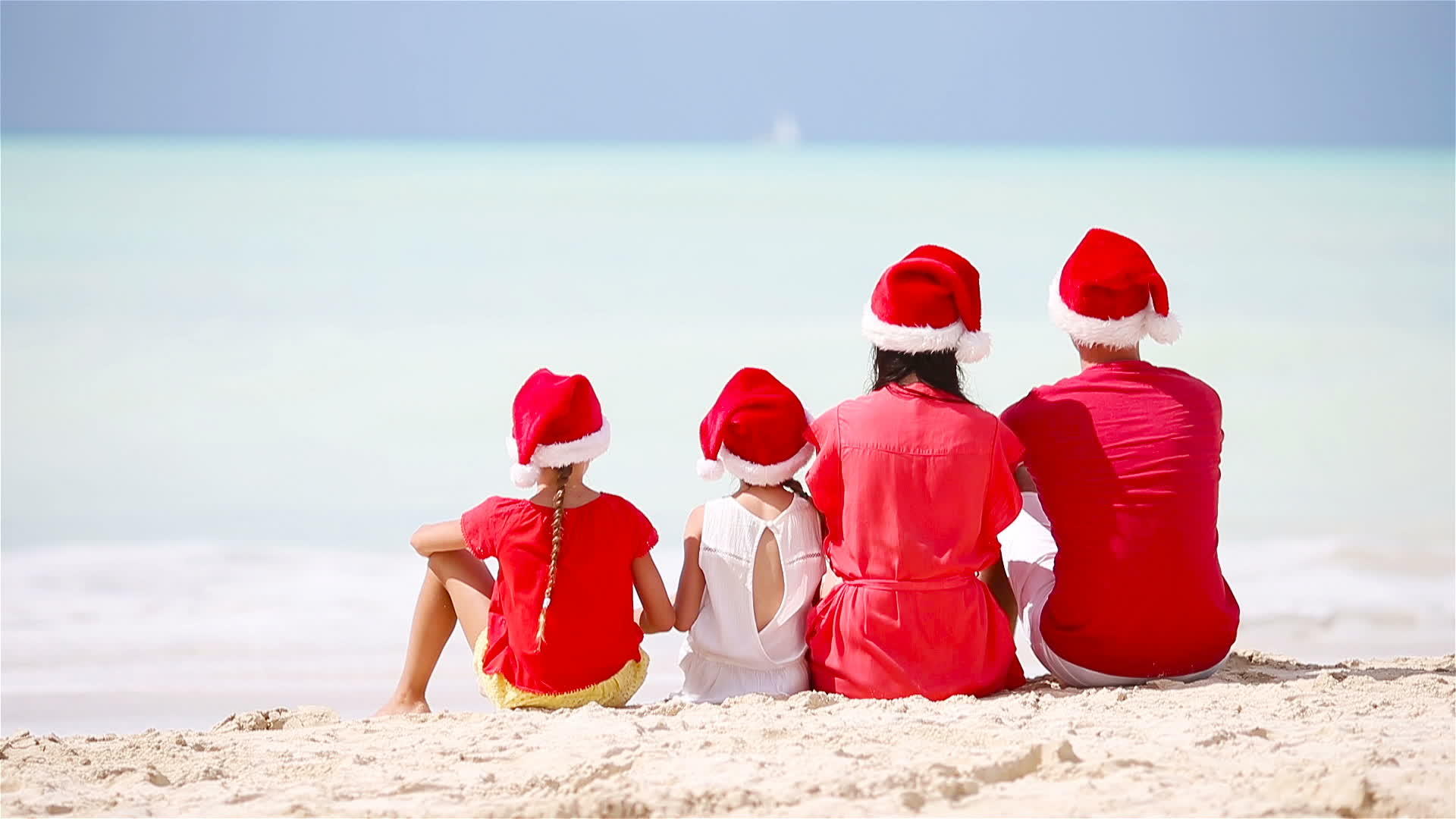 一家人在海边戴着圣诞帽视频的预览图