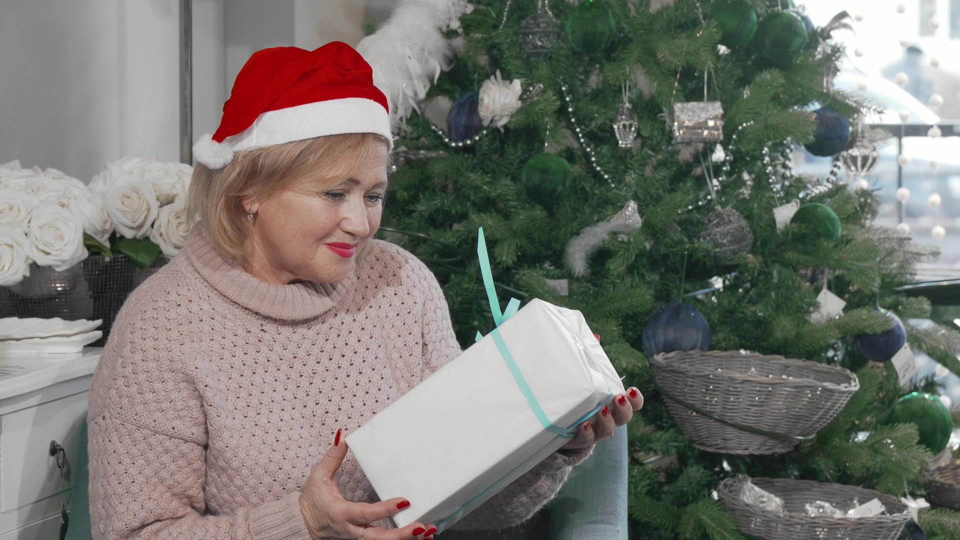 快乐的老妇人戴着圣诞礼物戴着圣诞礼物视频的预览图