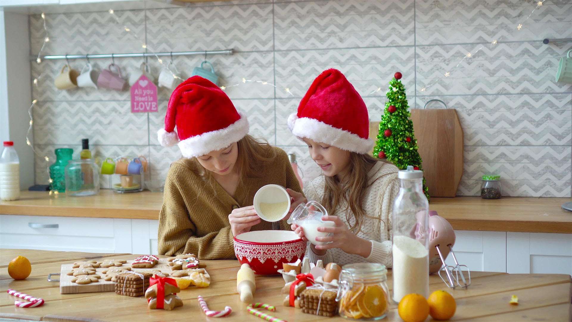 小女孩们在客厅的壁炉里做圣诞姜饼屋视频的预览图