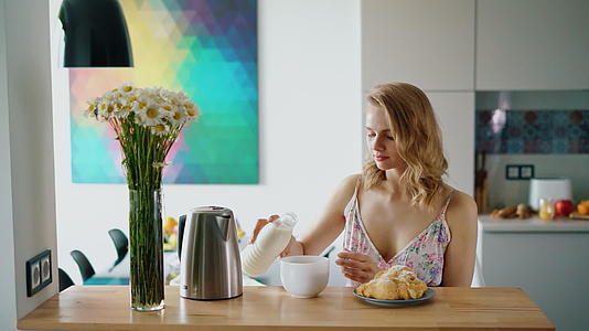 美丽的女孩准备咖啡加牛奶女人倒咖啡视频的预览图