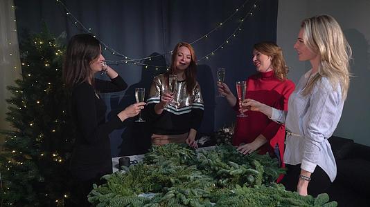 为庆祝圣诞节和新年做准备年轻女性用香槟碰杯视频的预览图