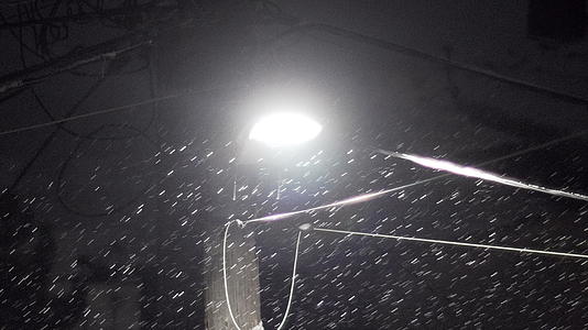深夜浓密的雪花和电线与热带光线相连视频的预览图