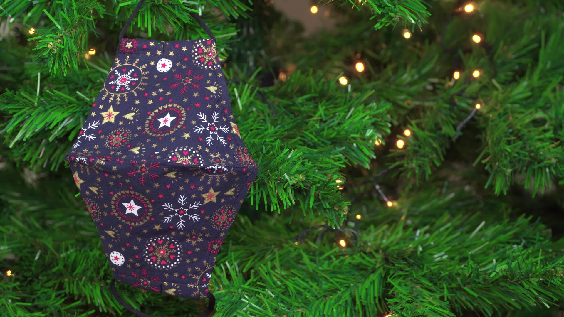 圣诞节用面具作为装饰挂在绿树上灯光照亮视频的预览图