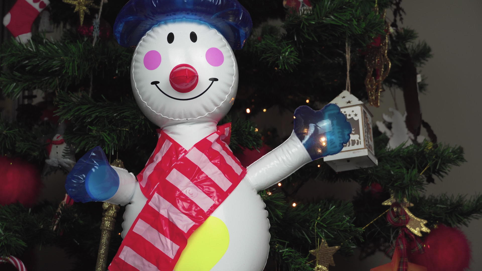 大型可充气玩具雪人装饰在圣诞树上视频的预览图