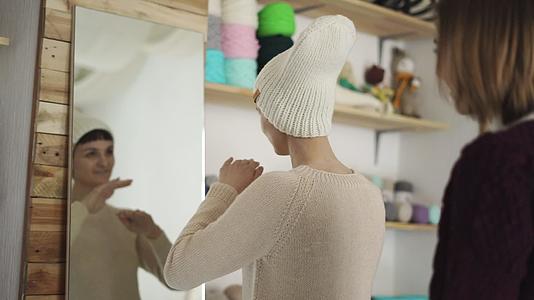 微笑的女人戴着编织的帽子在展厅照镜视频的预览图