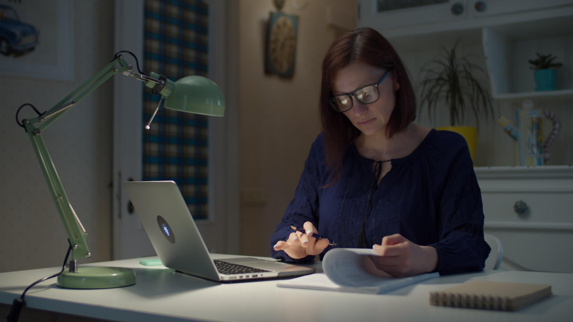 30多岁的年轻女商人在家工作签署纸质文件看着笔记本电脑视频的预览图