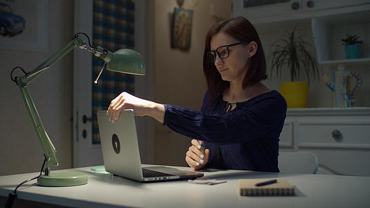 30多岁的年轻女性在家工作前在笔记本电脑上喷洒消毒剂视频的预览图