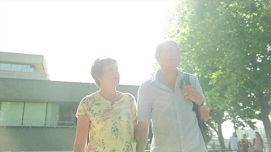隆登的活跃老人夫妇在阳光下行走视频的预览图