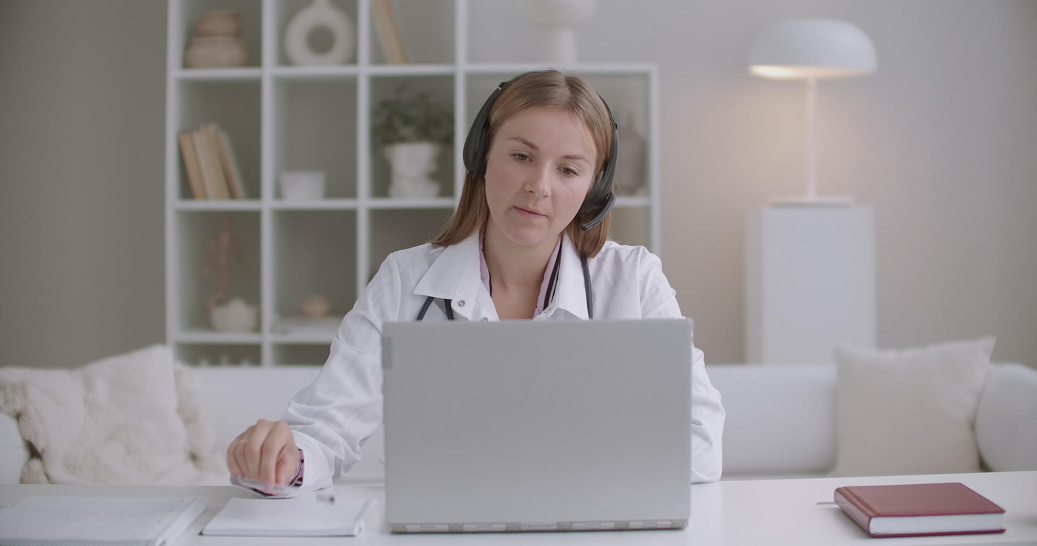 女治疗师通过视频电话在笔记本电脑上询问患者并记笔记视频的预览图