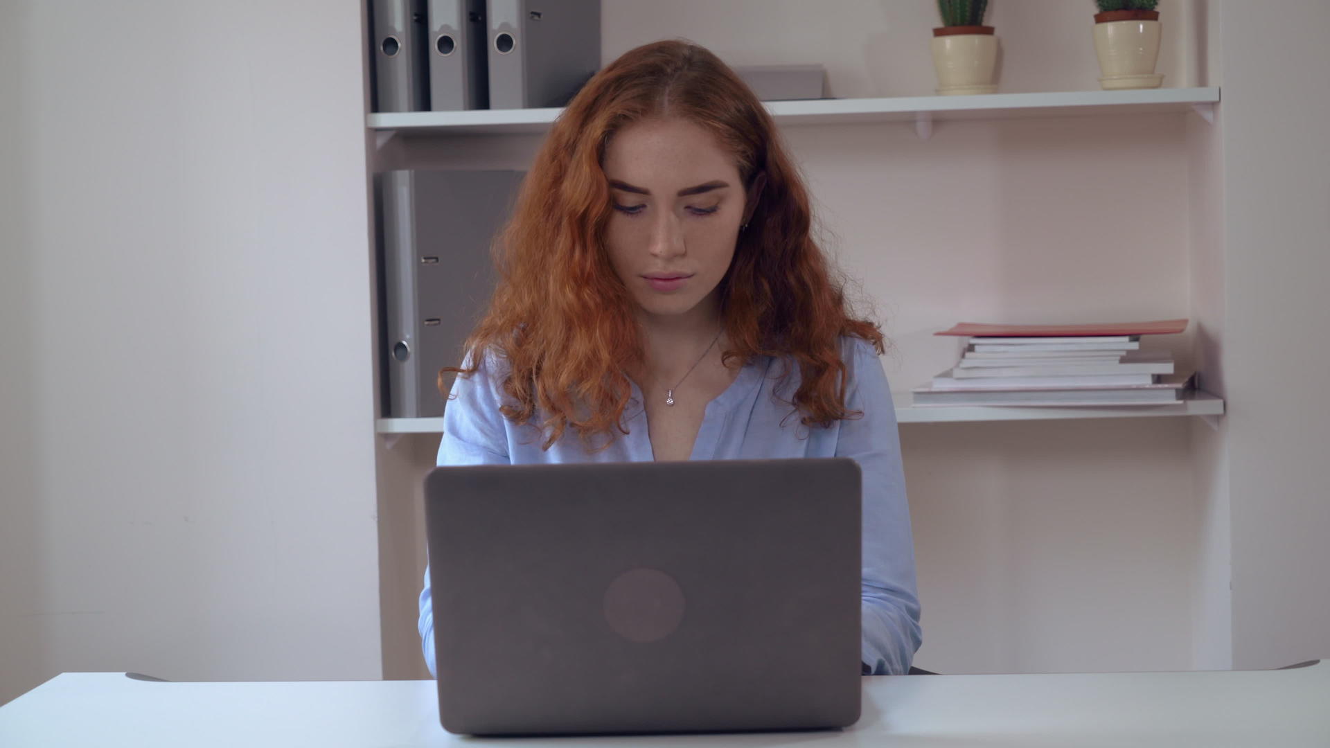 有卷发的年轻女性在电脑上工作视频的预览图