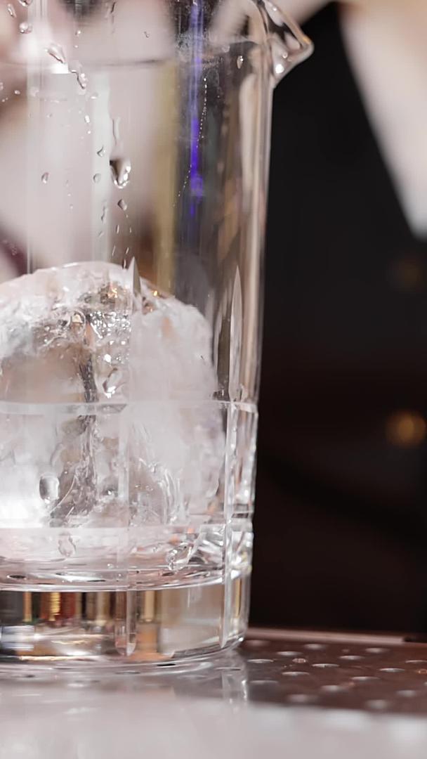 调酒师把冰块放进玻璃杯里视频的预览图