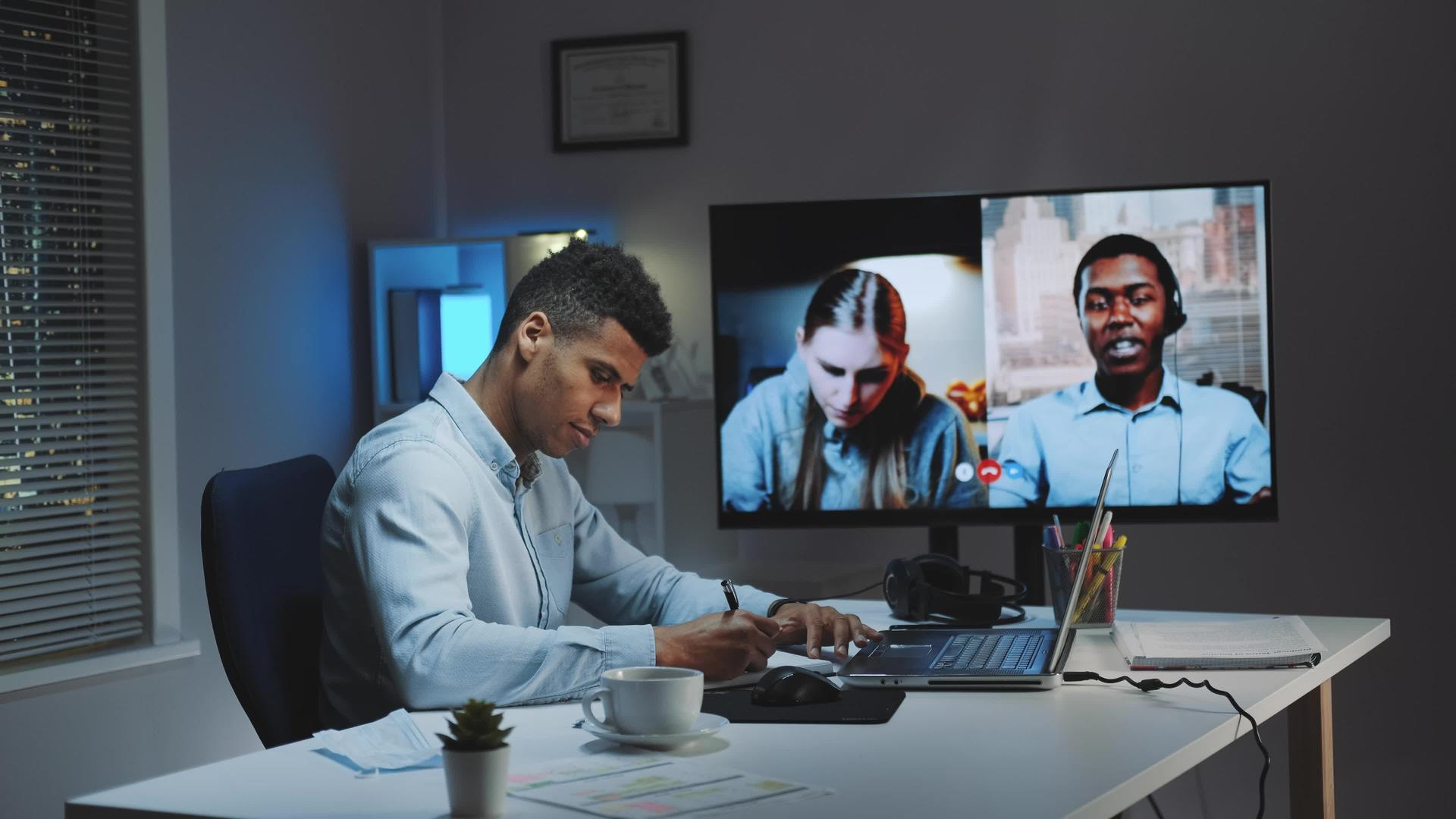 黑人首席总经理和同事在大型监视器上使用视频通话视频的预览图