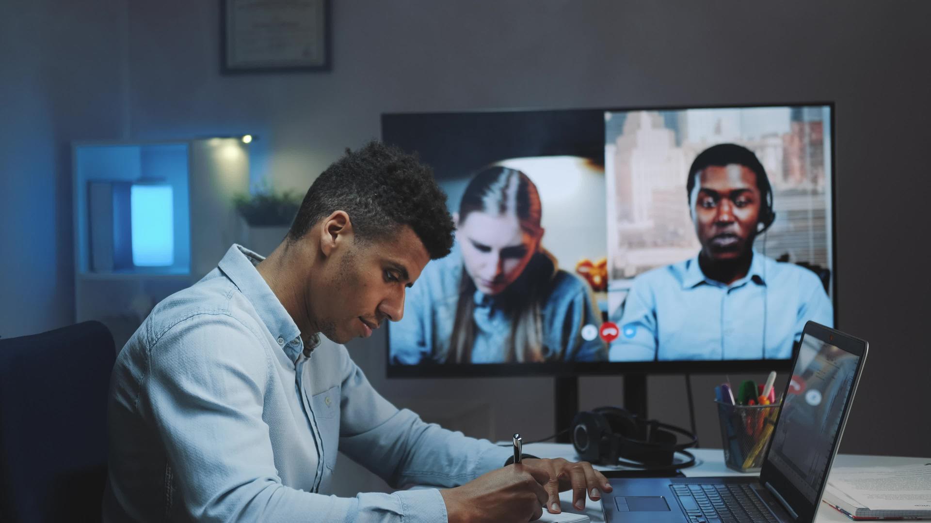 黑人总经理和他的同事在大型监视器上进行视频通话视频的预览图