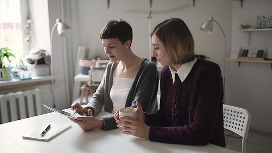 两名女学生使用平板电脑进行家庭在线教育视频的预览图