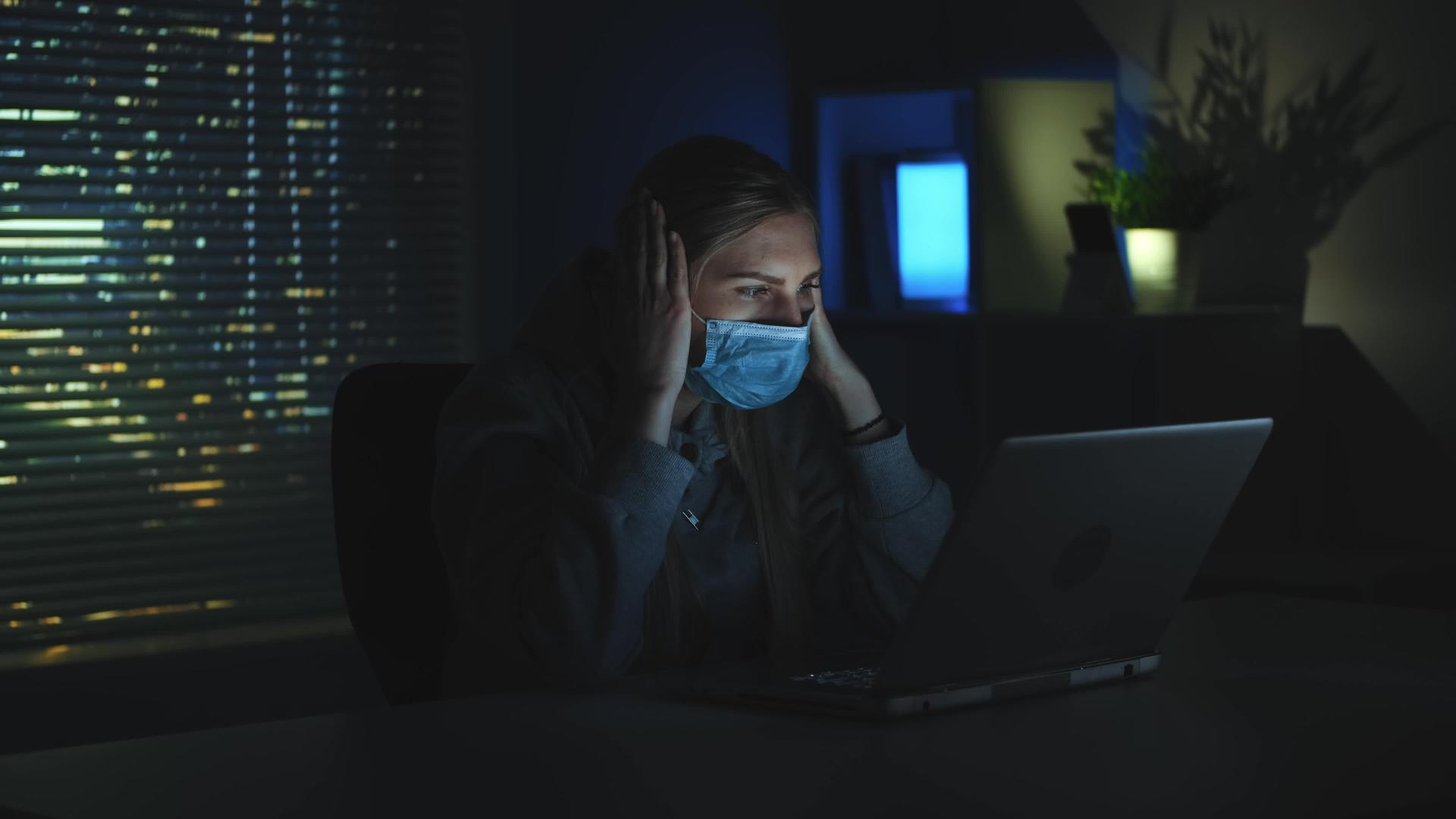 害怕的女人在黑暗中看着笔记本电脑视频的预览图
