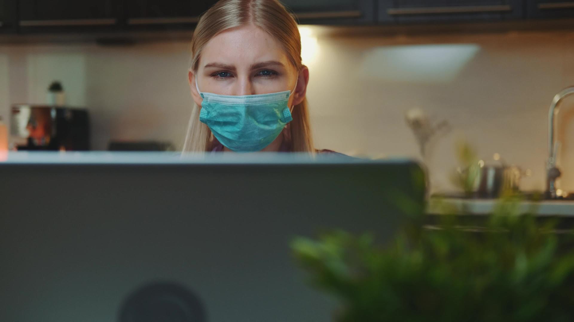 电脑监视器和戴着医疗面具的女性在屏幕前看到了一些视频的预览图