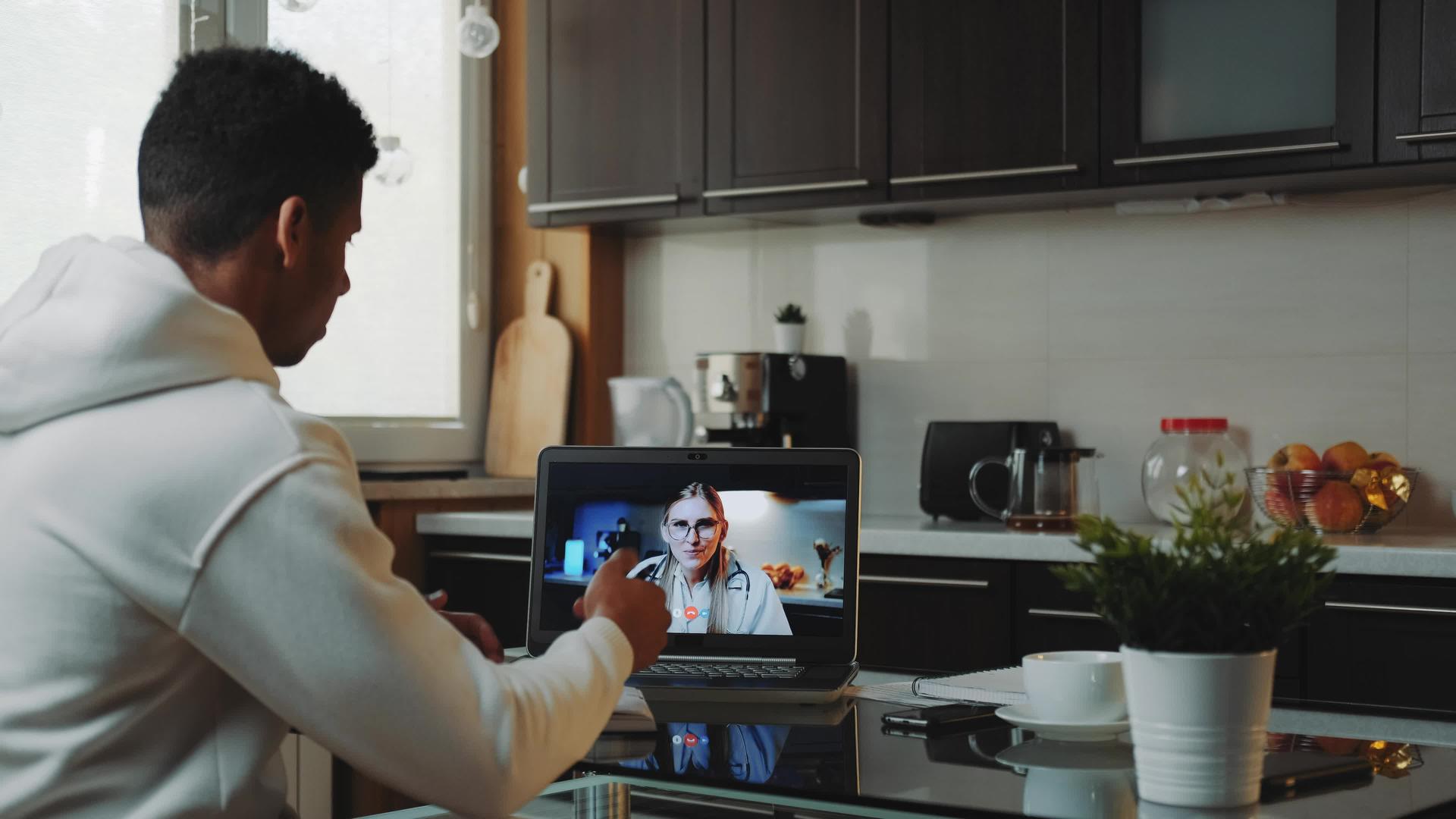 黑人男子在电脑上与女医生进行视频咨询视频的预览图