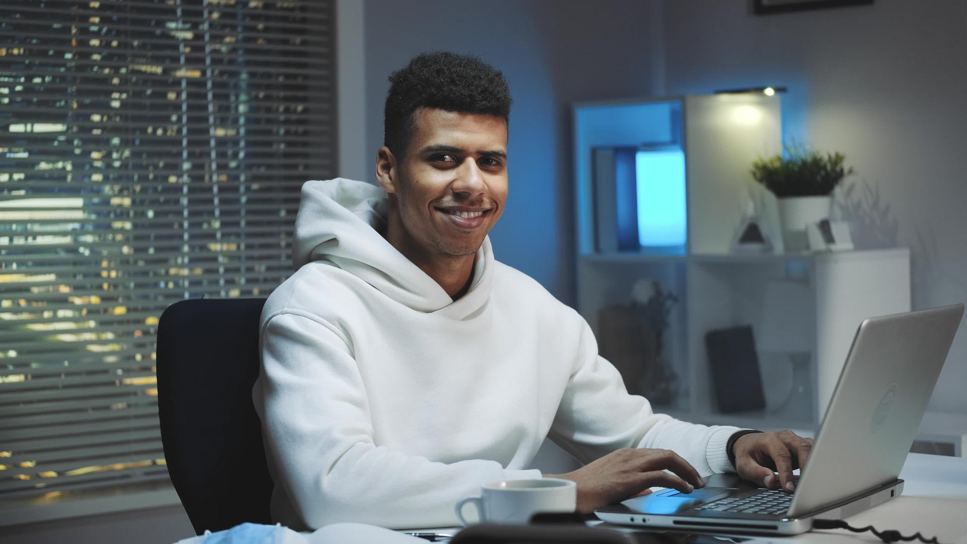 英俊的黑人在家工作时对着相机微笑视频的预览图