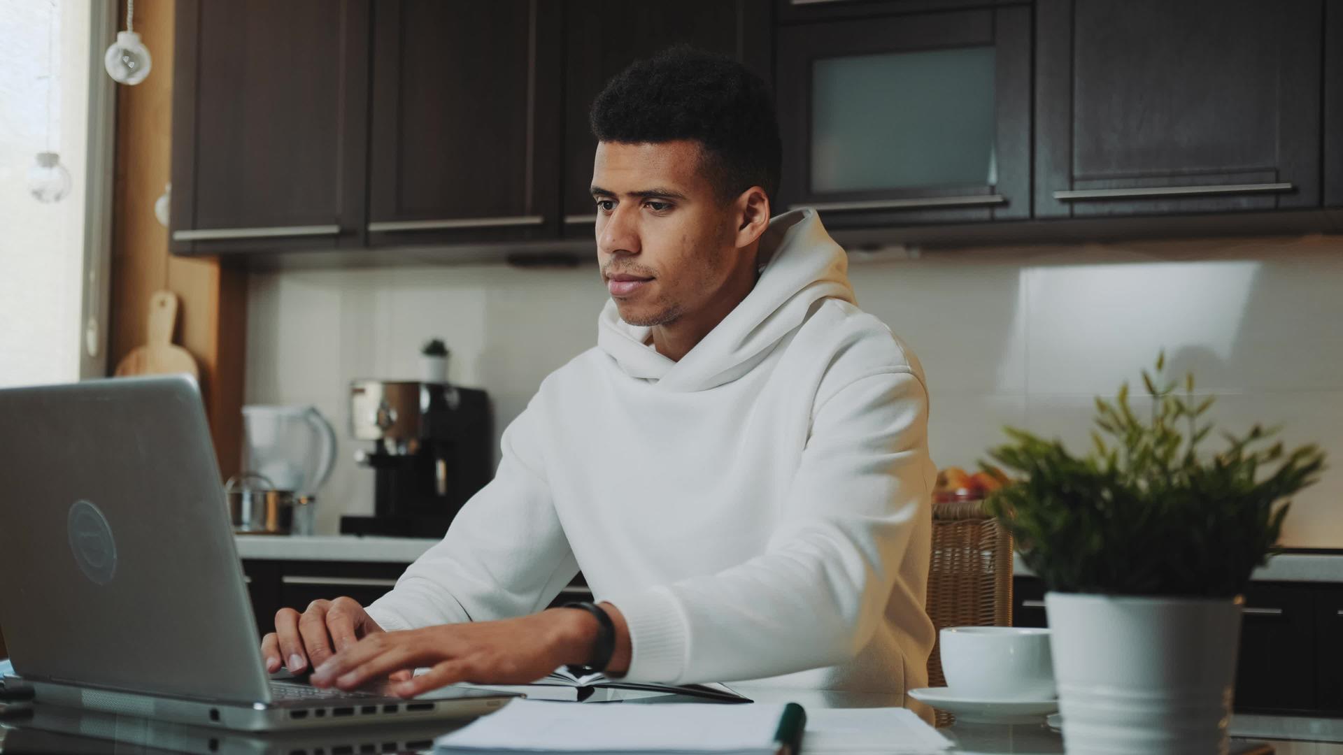 穿着白色内衣的黑人在家用电脑上工作视频的预览图