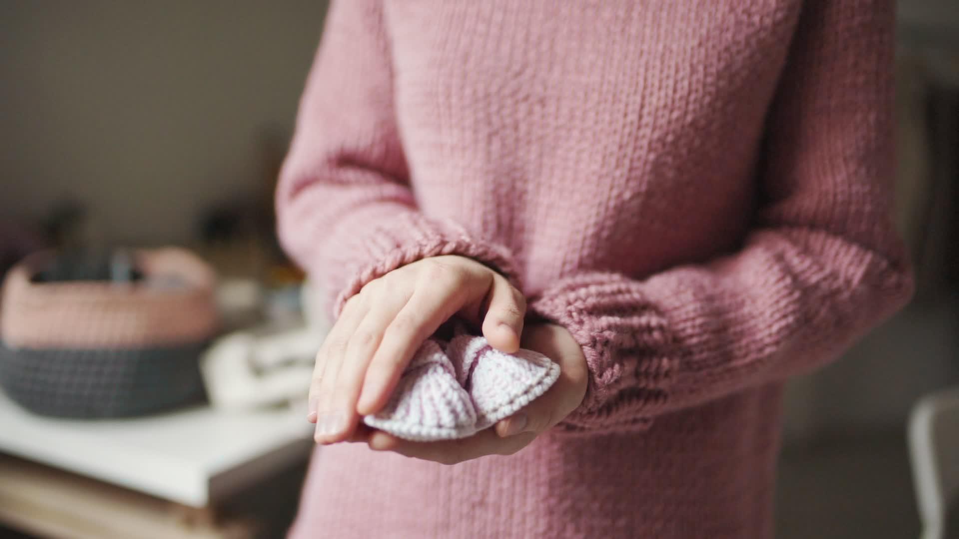 手工编织的女性手掌上的婴儿鞋视频的预览图