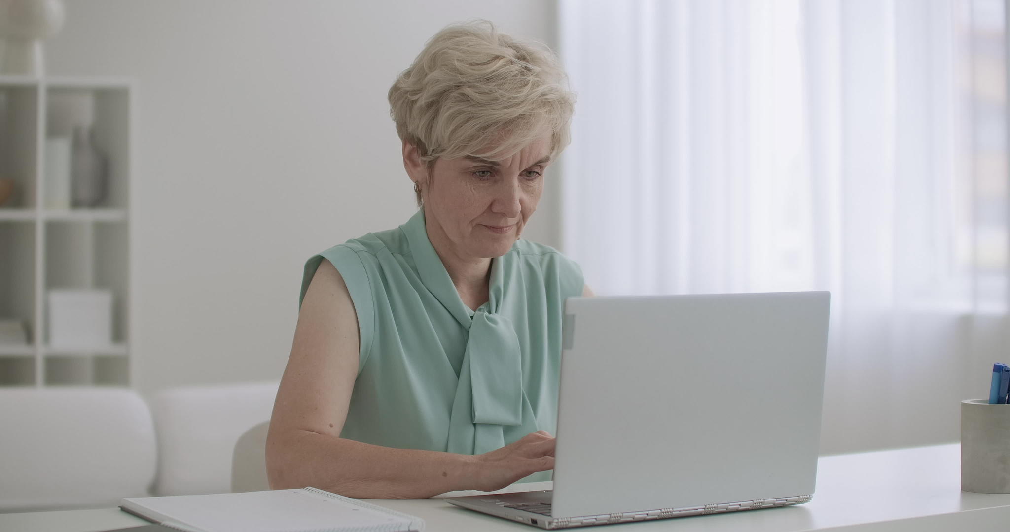 老女会计师在办公室用笔记本电脑工作女人在键盘上工作视频的预览图