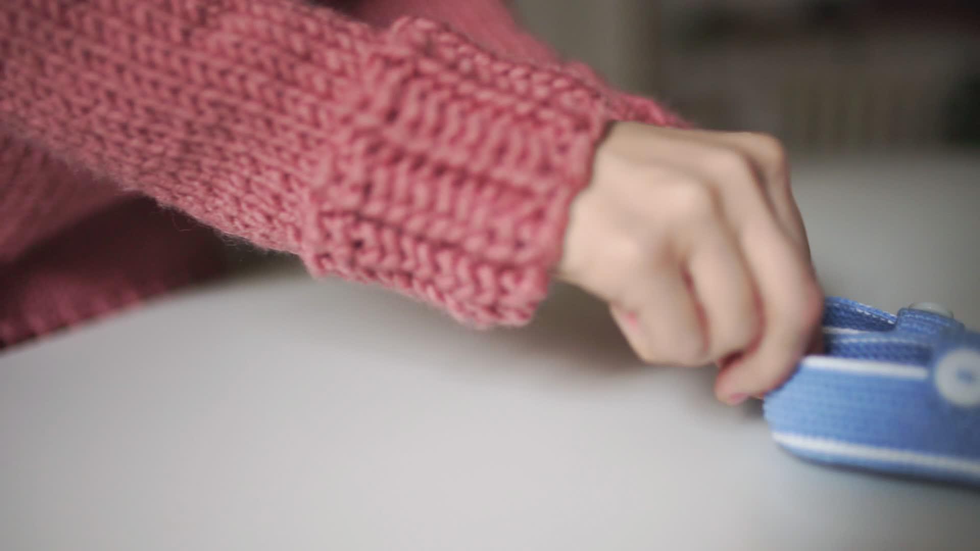 女用手编织婴儿靴的女用手为婴儿工制作的编织鞋视频的预览图