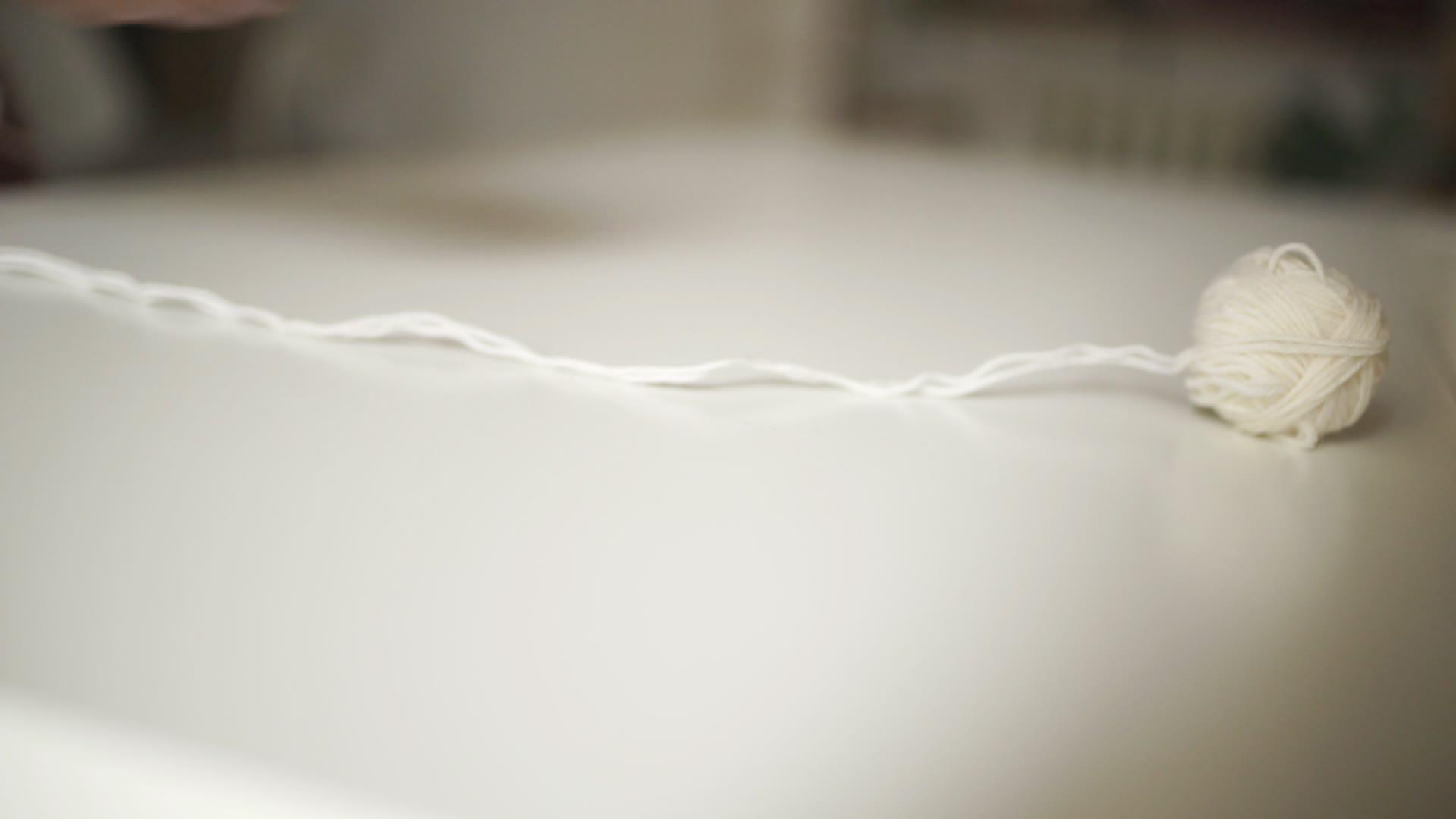 桌上滚动的纱球桌上的白色球毛线视频的预览图