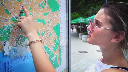 旅游女游客检查城市地图观光景点视频的预览图