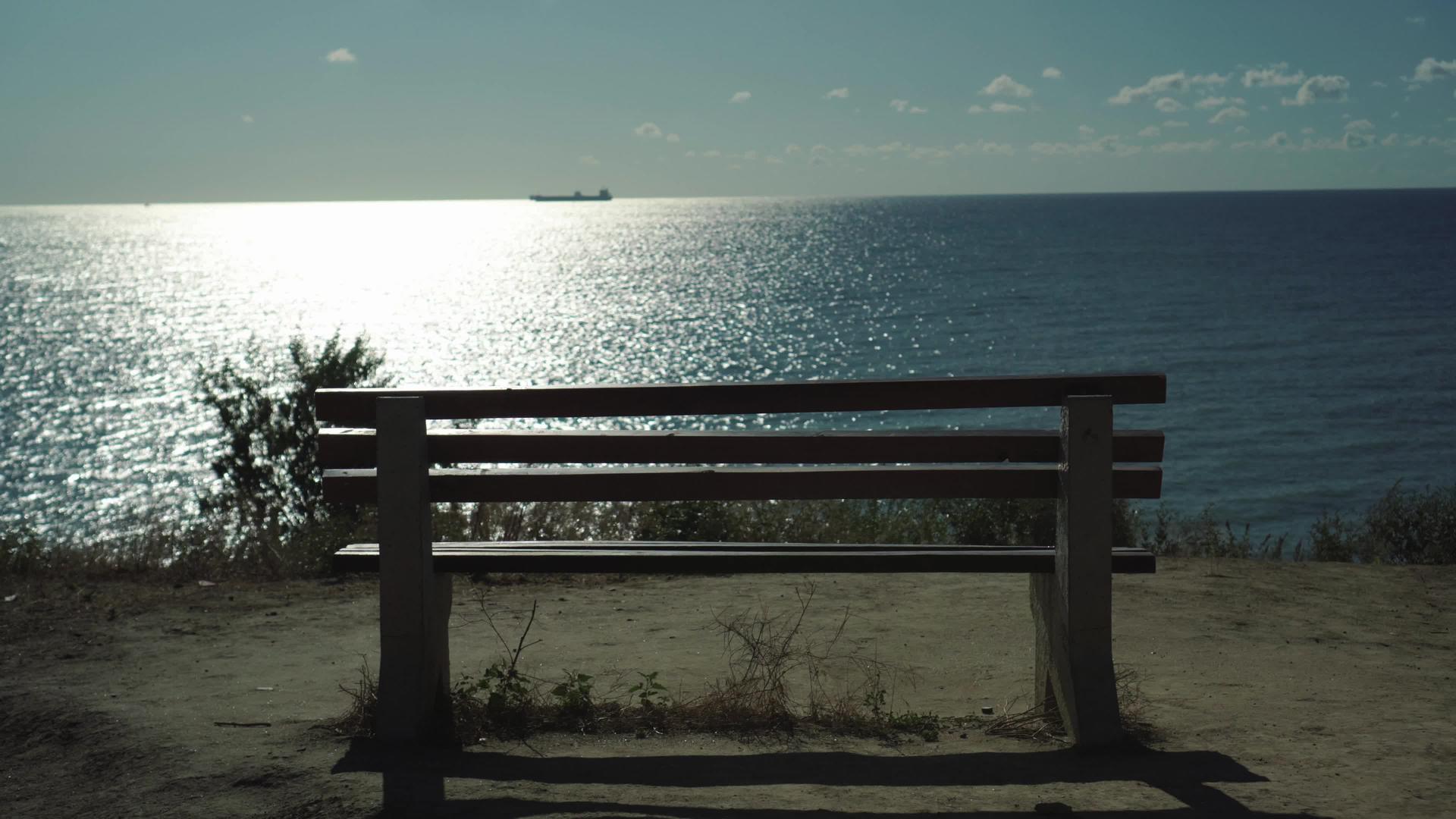 日落时俯视海面的单端海上木凳手持射击货船在地平线上视频的预览图