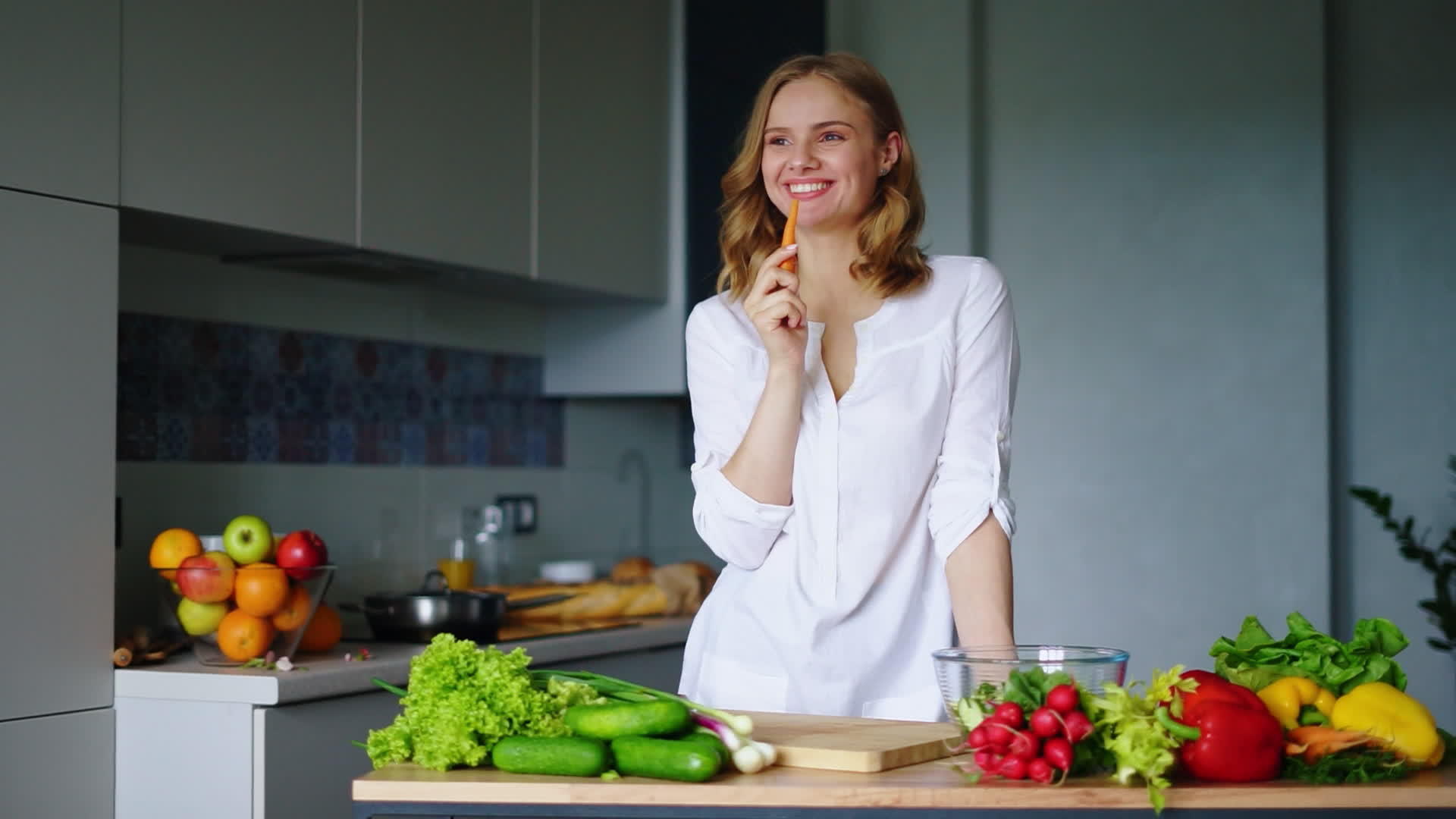 快乐女孩在厨房里吃胡萝卜健康饮食蔬菜视频的预览图