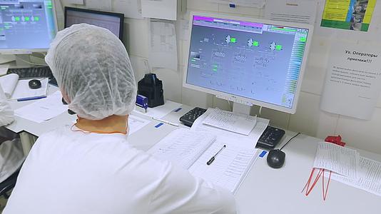 工厂操作人员在计算机控制中心查看数据视频的预览图