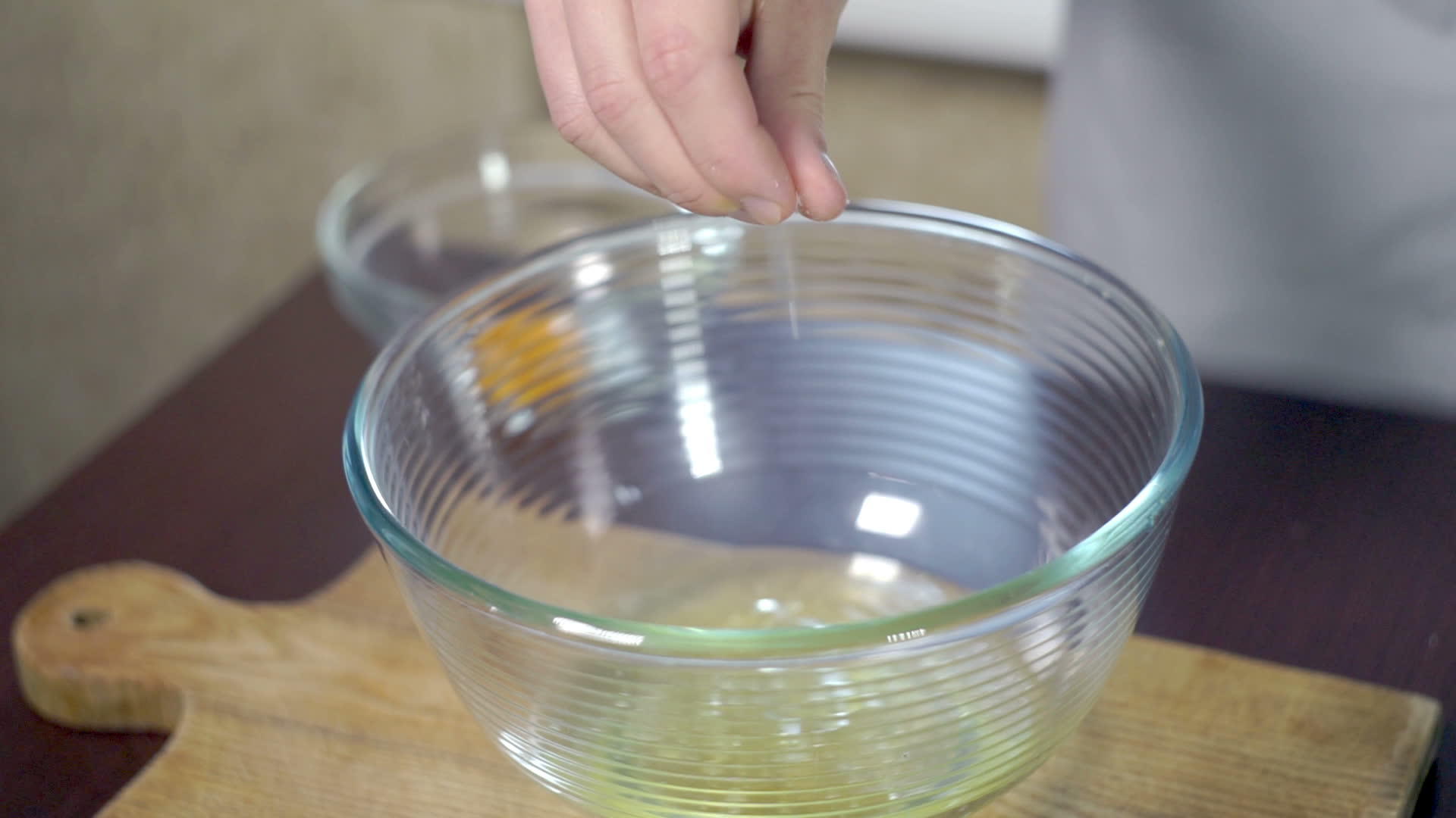 厨师在玻璃碗中的蛋白中加入盐视频的预览图