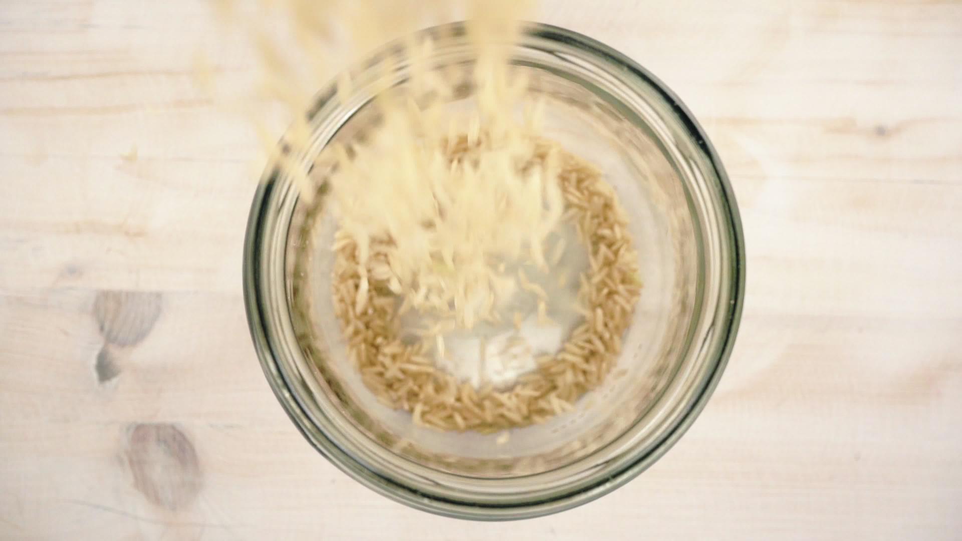 棕色大米倒入玻璃罐中视频的预览图