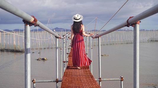 女性背影海边桥行走视频的预览图