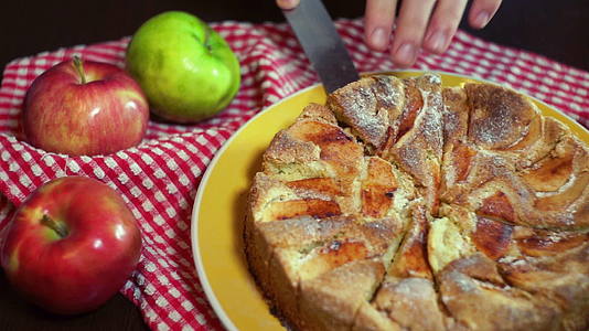 用小刀取出一块刚烤好的蛋糕烤苹果蛋糕视频的预览图