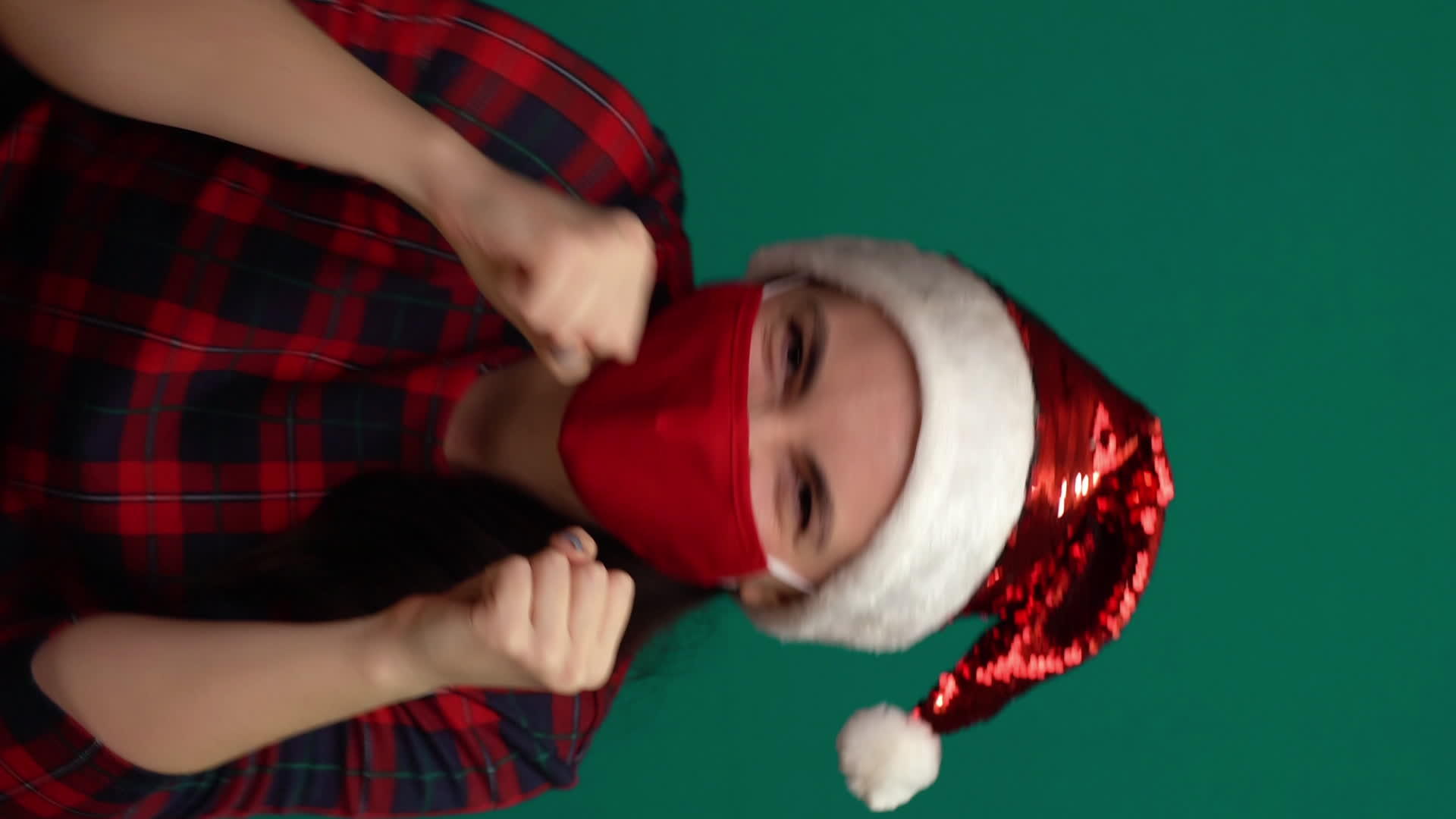 戴着圣塔帽和红色医疗面具的年轻美女用拳头与恐慌作斗争-Co【竖版】视频的预览图