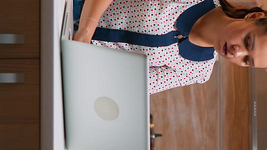 商业女性使用笔记本电脑在家工作垂直版视频的预览图