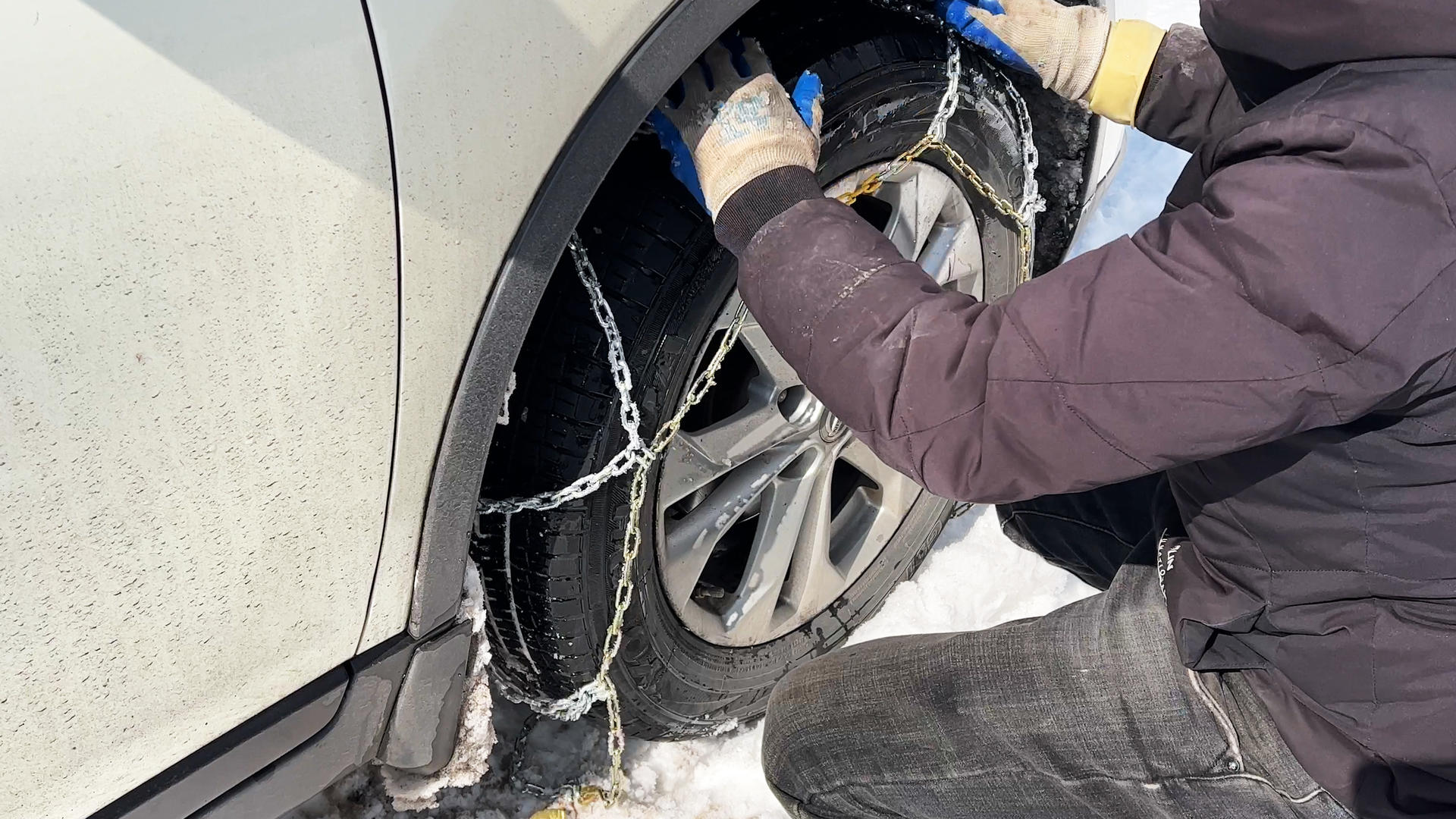 冬天下雪天给汽车安装防滑链避免事故的施工工人4k安全素材视频的预览图