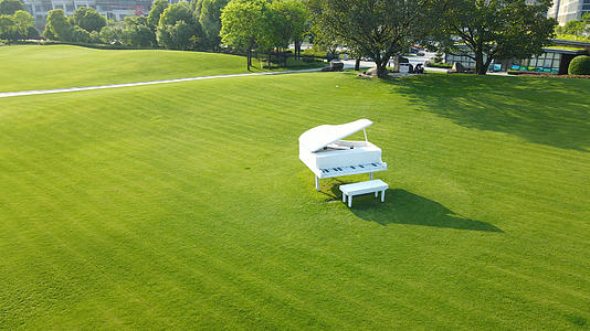 4K航拍唯美浪漫绿色草坪上的钢琴视频的预览图