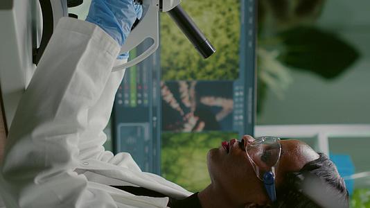 生物学家女性垂直视频在显微镜下观察样本垂直版视频的预览图