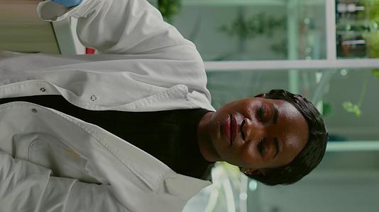 非洲妇女坐在制药实验室的办公桌旁视频的预览图