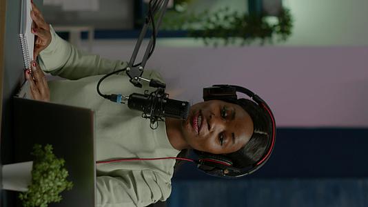 非洲社交媒体女性在笔记本电脑上用麦克风说话垂直版视频的预览图
