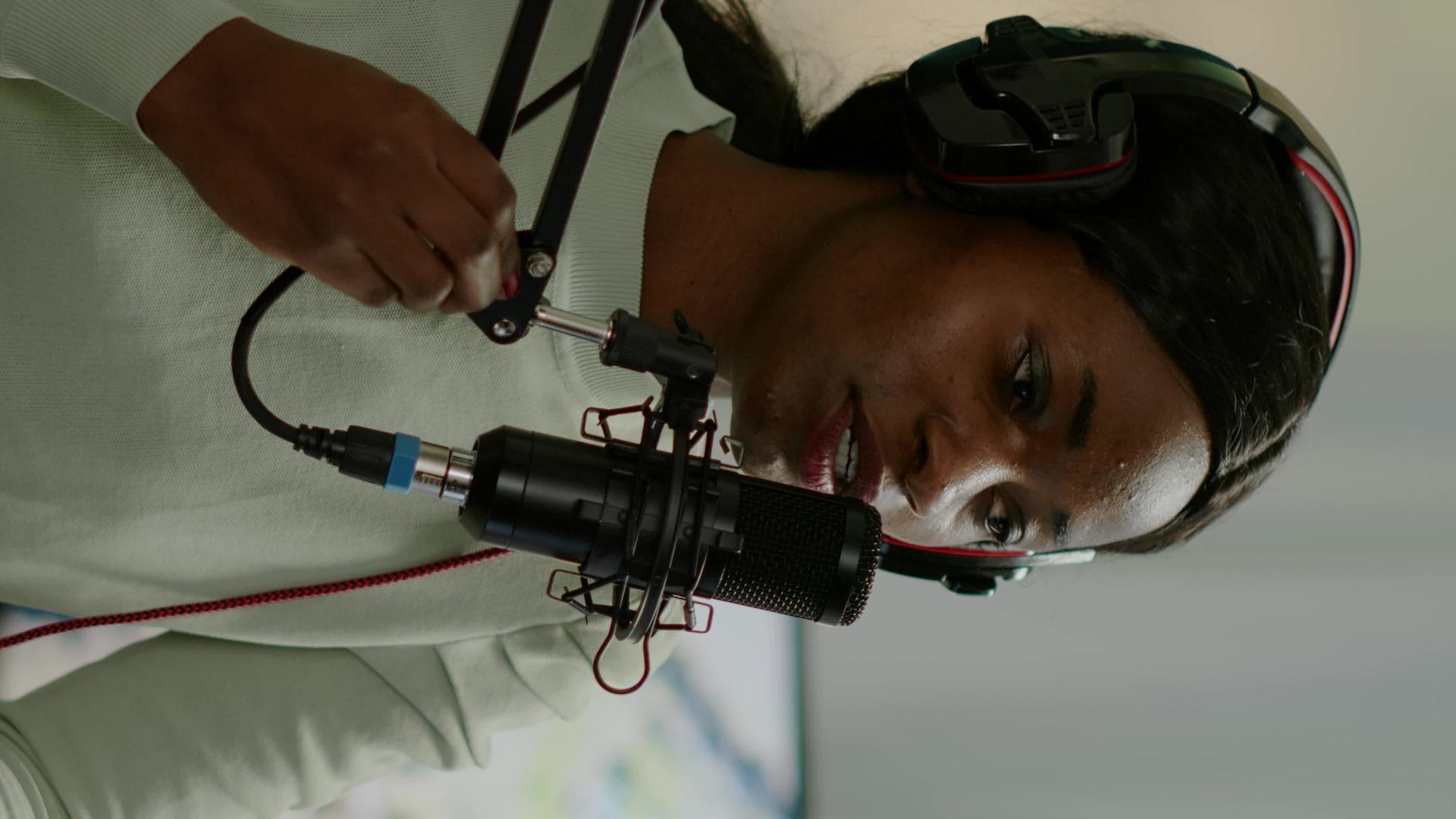 垂直视频非洲女性在线节目主持人用麦克风与非洲女性聊天垂直版视频的预览图