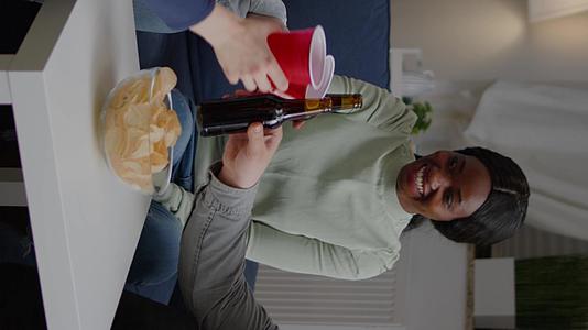 垂直视频多民族朋友花时间在夜生活派对上喝啤酒【竖版】视频的预览图