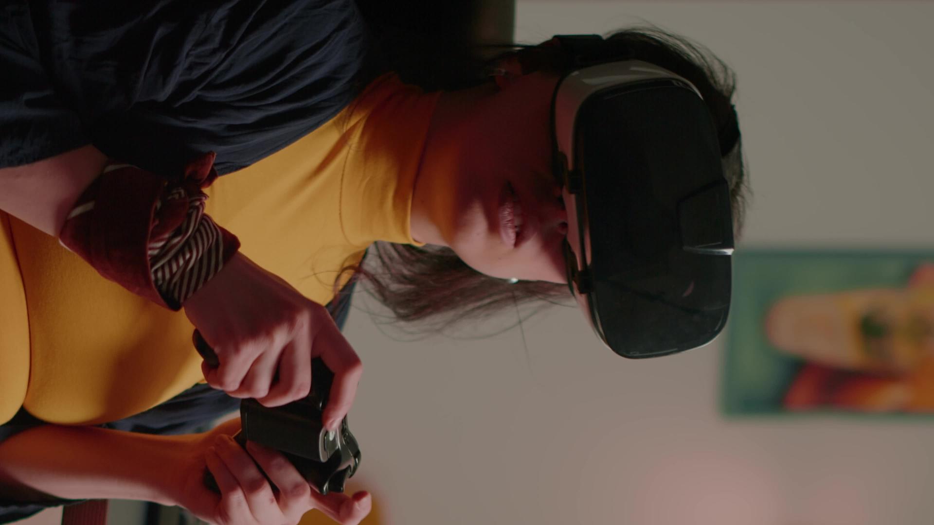 垂直视频玩家女性使用虚拟现实网格赢得太空射击游戏的【垂直版】视频的预览图