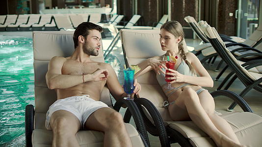 男人和女人在甲板椅上喝鸡尾酒视频的预览图