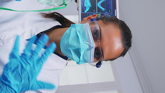 垂直视频牙医依靠在患者身上佩戴氧气面罩患者的第一视角垂直版视频的预览图