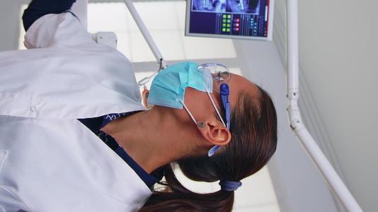 医生在牙科检查前测量女性体温垂直版视频的预览图