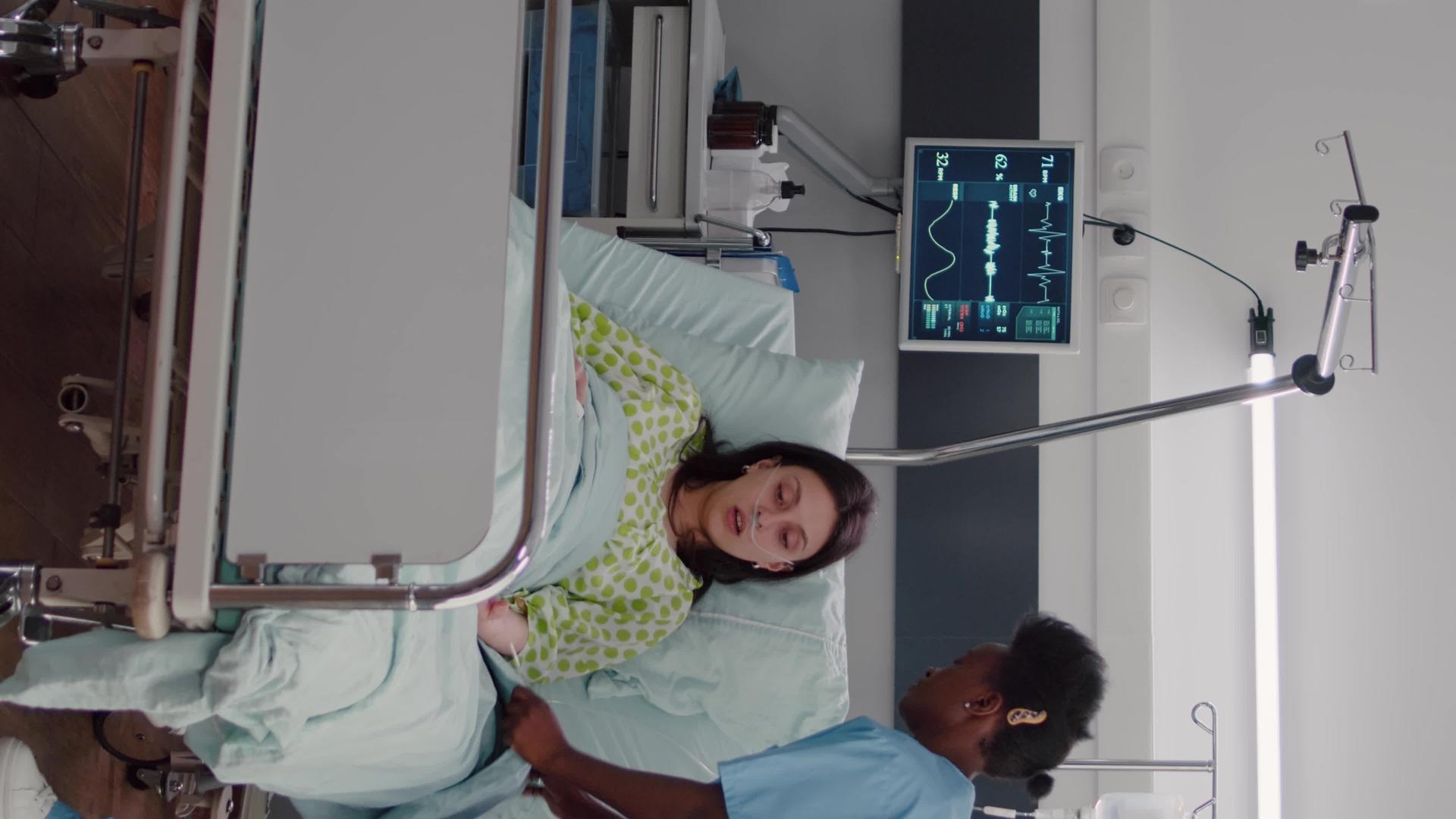 美国护士在医疗康复期间安排患病妇女的床位【垂直版】视频的预览图