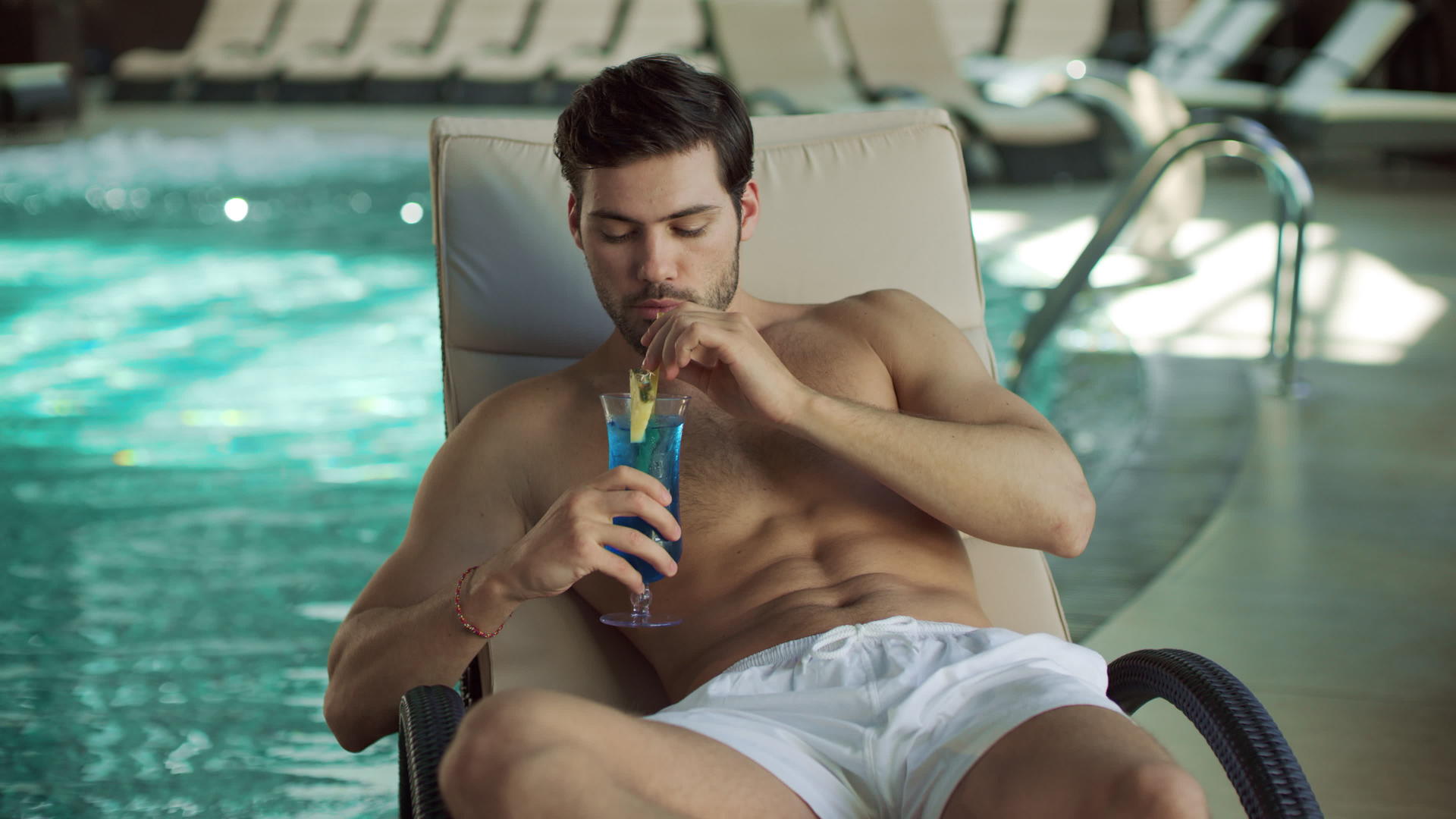 男人在现代游泳池里喝鸡尾酒视频的预览图